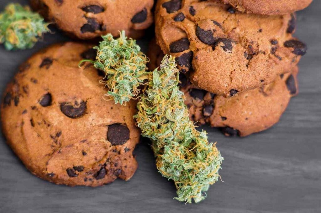 Cookies with cannabis and buds of marijuana on the table.