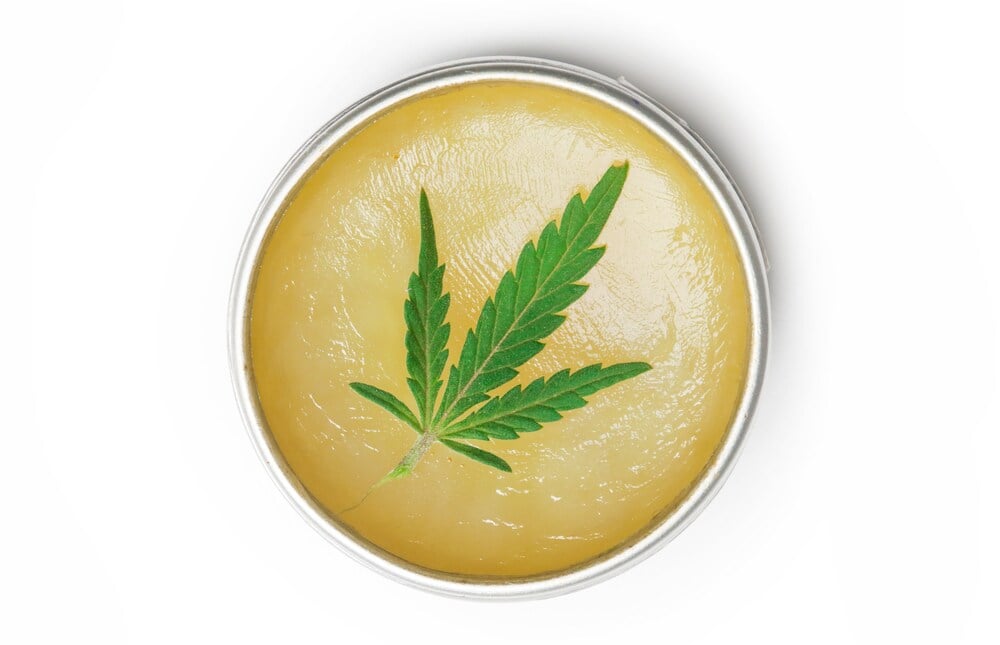 Cannabis cream with cannabis leaf top of it